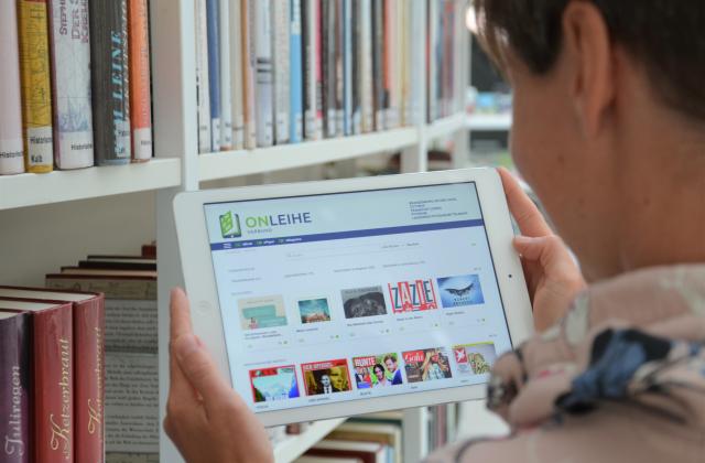 Nutzerin schaut auf Tablet in die eBibliothek