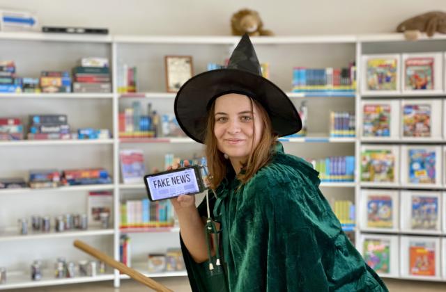 Hexe mit Fake News auf dem Handy
