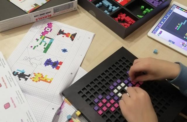Kinderhände mit dem Spiel Bloxels